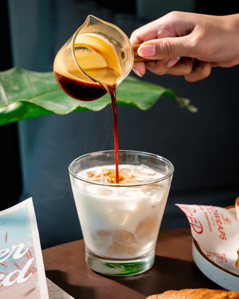 Pour-over coffee being poured over ice
